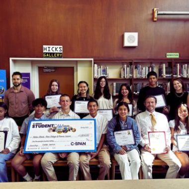Student recipients of the C-SPAN award pose with an oversized check.